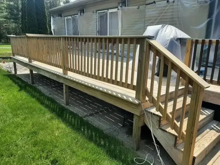 Wooden deck with railing attached to a mobile home, showing freshly cleaned and stained wood